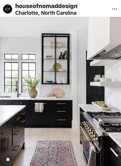 a kitchen with black cabinets and white counter tops, an area rug in front of the stove