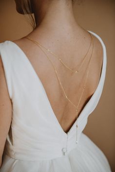 Elara Backdrop Necklace Perfect for any bridal gown with a plunging back, our Elara Back Necklace features petite marquise crystals that elegantly drape across your back. This back-drop necklace is the perfect keepsake.  Available in Gold. Dimensions: Chain drops 13.5" down the back. Our earrings, necklaces and bracelets are lead, nickel and cadmium free. These pieces are hypo-allergenic and are safe for sensitive skin and ears. Each order is thoughtfully gift wrapped and shipped in a gold embos Bride Back Necklace, Bridal Drop Necklace, Necklace That Goes Down Back, Elegant Backless Backdrop Necklace For Wedding, Dainty Drop Backdrop Necklace For Wedding, Elegant Gold Backdrop Necklace For Bride, Elegant Drop Backdrop Necklace For Wedding, Delicate Teardrop Backdrop Necklace For Weddings, Gold Teardrop Backdrop Necklace For Weddings