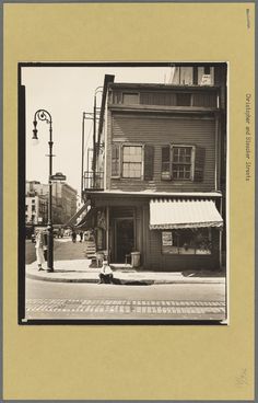 an old black and white photo of a street corner with a store on the corner