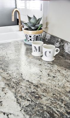 two coffee mugs sitting on top of a marble counter