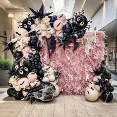 an arrangement of balloons and decorations in the shape of bats, spider webs, and skulls