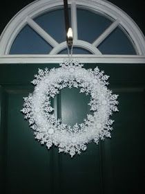 a green door with a white wreath hanging from it's side