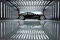 a black sports car parked in an empty garage