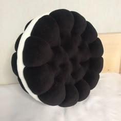 a black and white pillow sitting on top of a bed