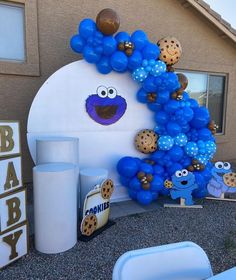 balloon arch with cookie monster balloons and cookies on it for an outdoor baby shower or birthday party