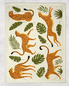 an animal themed tea towel with cheetah, leopards and palm leaves on it