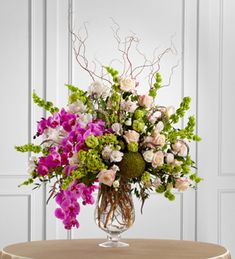 a vase filled with lots of flowers on top of a table