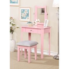 a pink vanity table with a mirror and stool