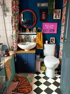 a bathroom with blue walls, black and white checkerboard flooring and a toilet