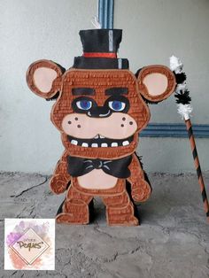 a paper sculpture of a bear wearing a top hat and holding a broom