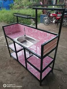 an outdoor sink made out of metal and pink marble