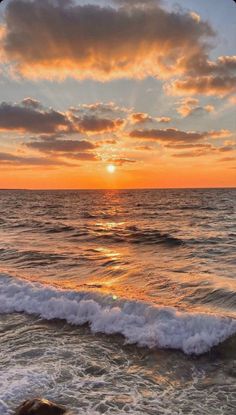 the sun is setting over the ocean with waves