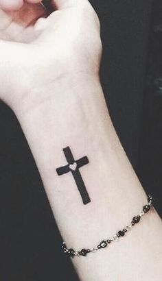 a person with a cross tattoo on their wrist