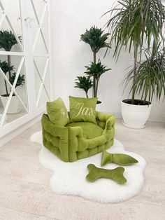 a green chair sitting on top of a white rug next to a potted plant