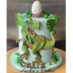 a dinosaur cake with an egg on top