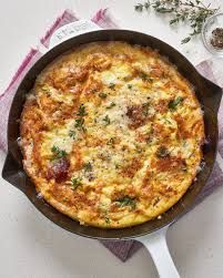 an omelet with cheese and herbs in a cast iron skillet on a table