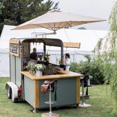 an outdoor food cart is set up in the grass for people to eat and drink