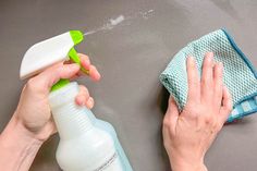 a person is cleaning the table with a spray bottle and microfit cloth on it