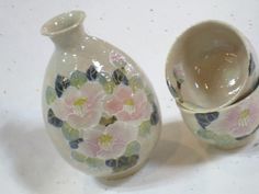 two small vases with flowers painted on them