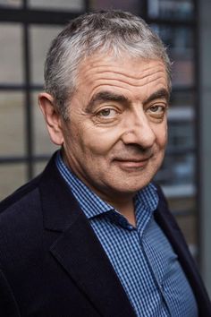 an older man wearing a suit and blue shirt looking at the camera with a surprised look on his face