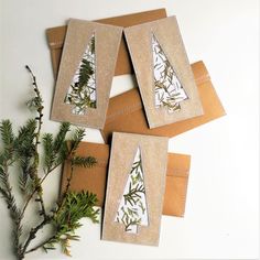 four brown envelopes with green leaves on them