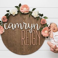 a woman holding a baby in front of a sign that says, canyon regn