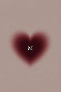 a red heart with the letter m in it's center and an overexposed photo