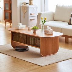 a living room with a couch, coffee table and other items on the floor in front of a window