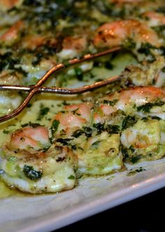 shrimp and broccoli casserole on a white plate with gold serving utensils