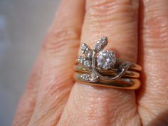 a close up of a person's hand with a ring on it and two diamonds in the middle