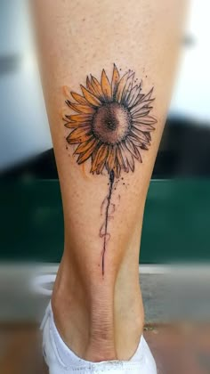 a woman's foot with a sunflower tattoo on her left leg and bottom