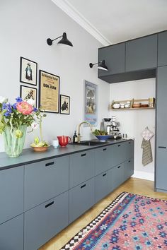 a kitchen with gray cabinets and an area rug