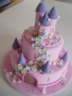 a pink cake with purple castle on top