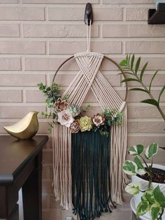 a macrame wall hanging with flowers and greenery