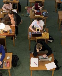 several people sitting at desks working on laptops