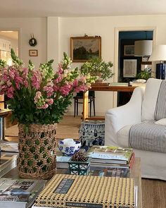 a living room filled with lots of furniture and flowers in vases on the coffee table