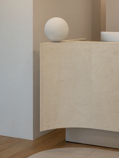 a white vase sitting on top of a counter next to a wall mounted light fixture