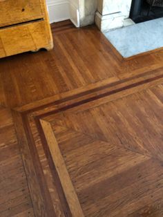 a wooden floor with a fire place in the background