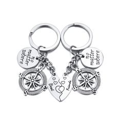 two keychains with different designs and words on them, one has a compass