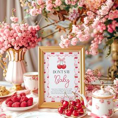 a table topped with plates and cups filled with desserts next to a framed sign that says, don't say baby