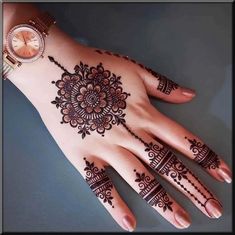 a woman's hand with henna tattoos on it