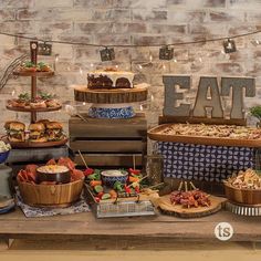 a table topped with lots of food next to a brick wall