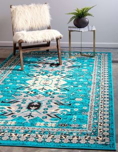 a blue area rug with a chair and plant in the corner next to it on top of a hard wood floor