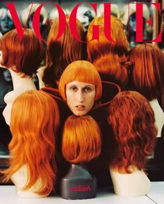 a magazine cover with mannequins and red hair on display in front of the camera