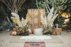 an outdoor area with plants and rugs on the ground