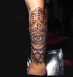 a person with a tattoo on their arm and hand holding an eye in the middle