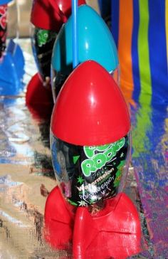 an assortment of colorful toys sitting on top of a wet surface in the water at a carnival