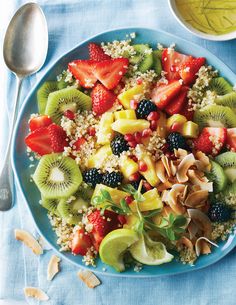 fruit salad with nuts, kiwis, strawberries and other fruits on a blue plate