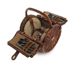 a wicker picnic basket with utensils and plates in it on a white background