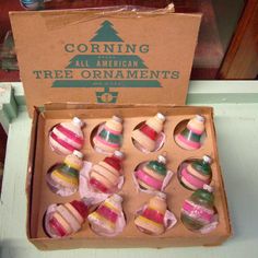 a box filled with lots of different colored cupcakes on top of a table